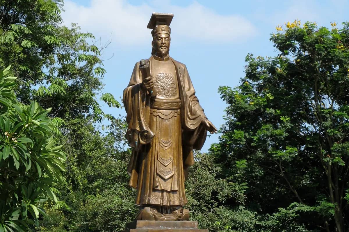 The bronze statue of King Ly Thai To, who made the city his capital as Thang Long in 1010, holding a scroll by Hoan Kiem Lake in Hanoi