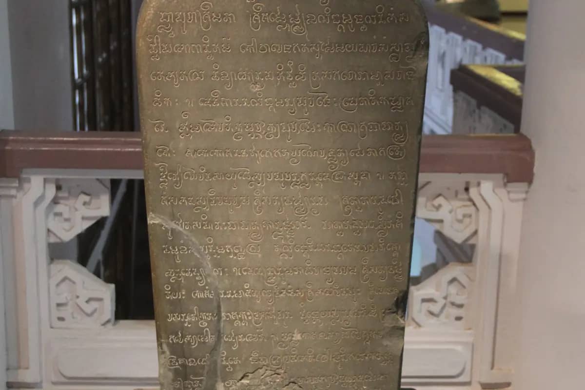 A sandstone stele from Po Nagar covered in lines of carved Cham script, displayed in a museum