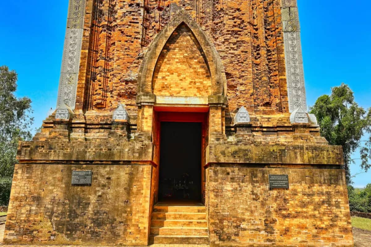 The brick Canh Tien tower, which stands in the old Cha Ban citadel of Vijaya, with its arched doorway under a blue sky