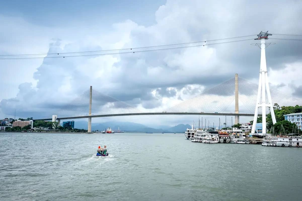 Tour boats moored on the Bai Chay waterfront beside the cable car tower, Bai Chay Bridge behind
