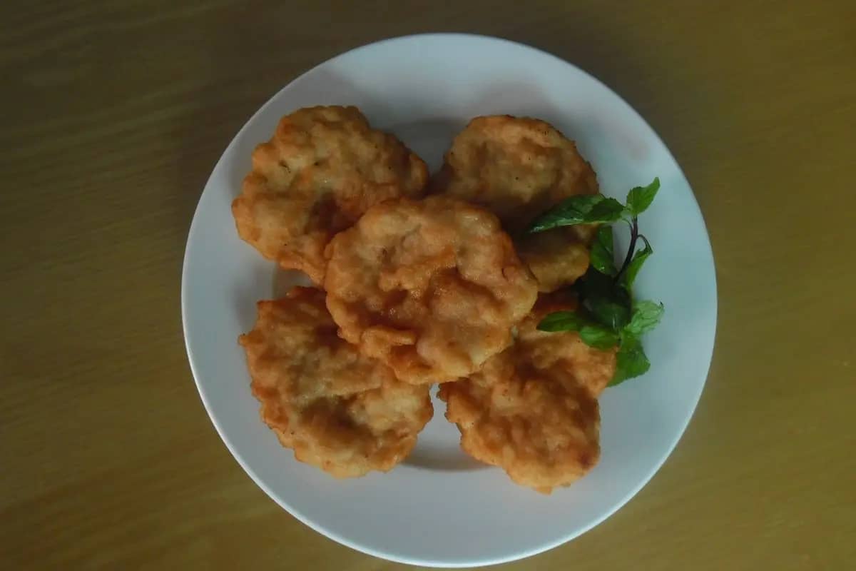 A plate of cha muc, golden fried Ha Long squid cakes, with a sprig of herbs