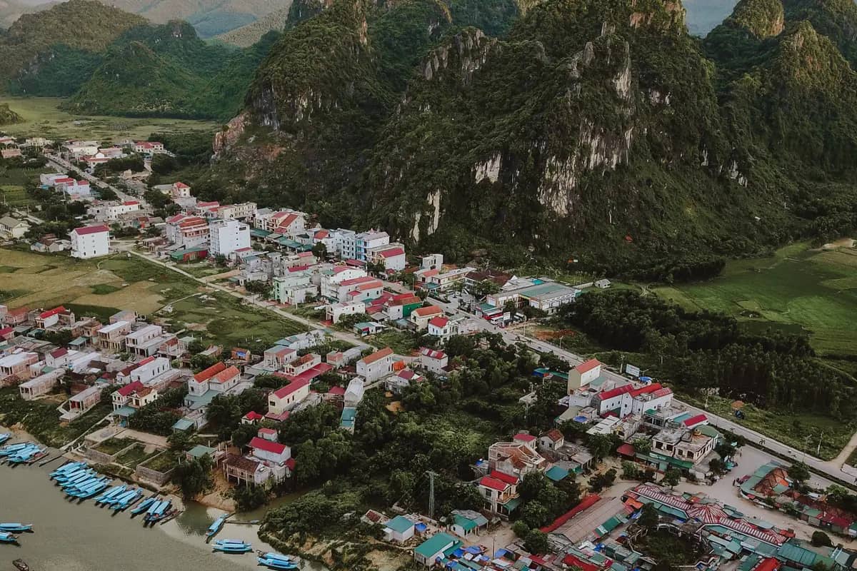 Phong Nha town from the air before sunset, boats moored on the Son River below the karst peaks