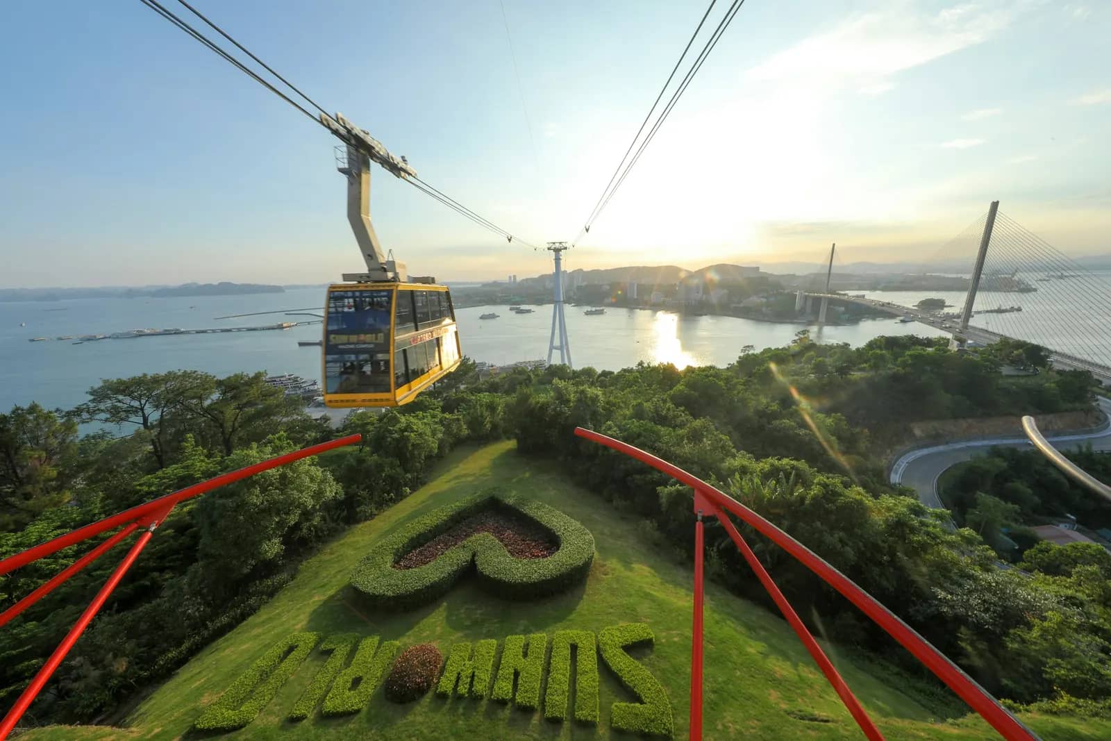 A cable car above the green slopes of Bai Chay, the sea behind