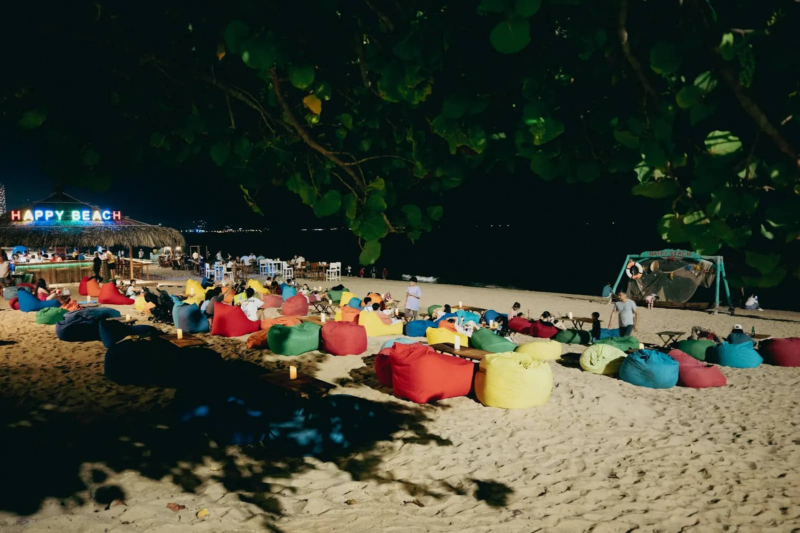 Colourful beanbags set out on the beach at night