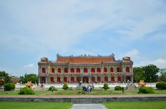 The ornate yellow and red Kien Trung Palace in Hue's Imperial City under a bright blue sky