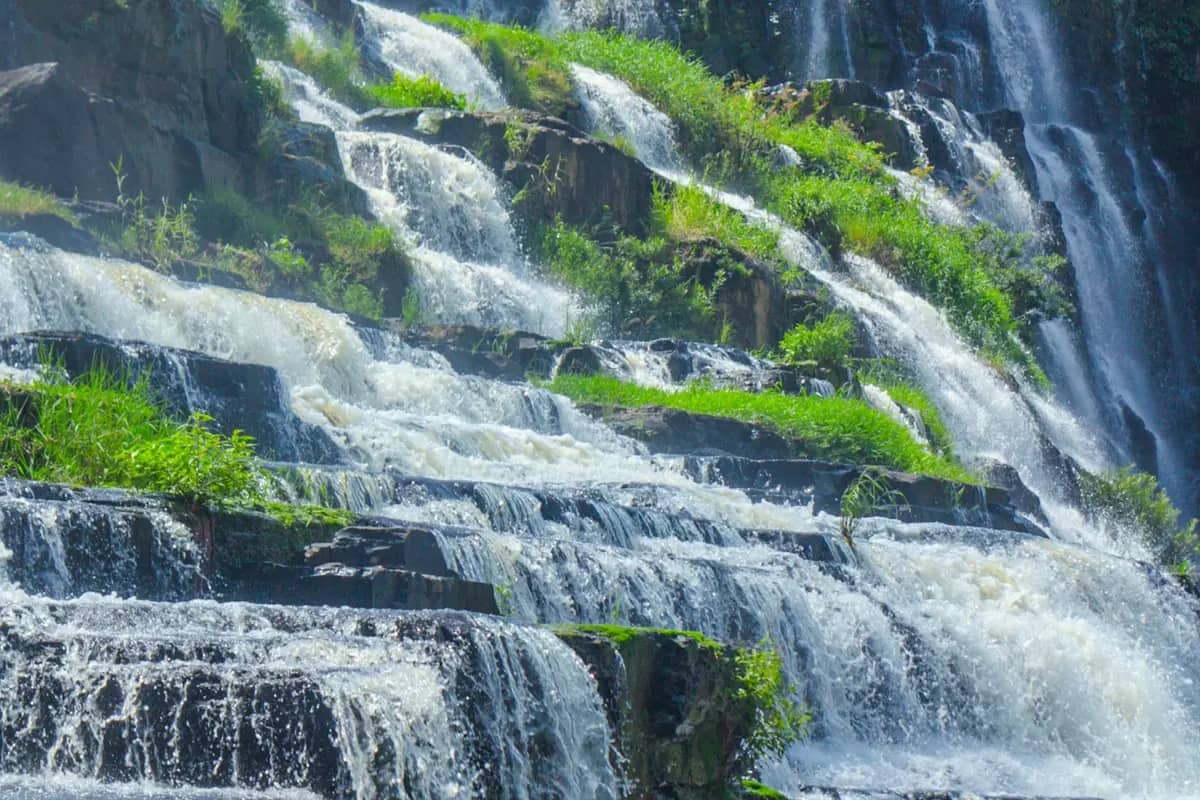 Water pouring over the wide rock steps of Pongour falls
