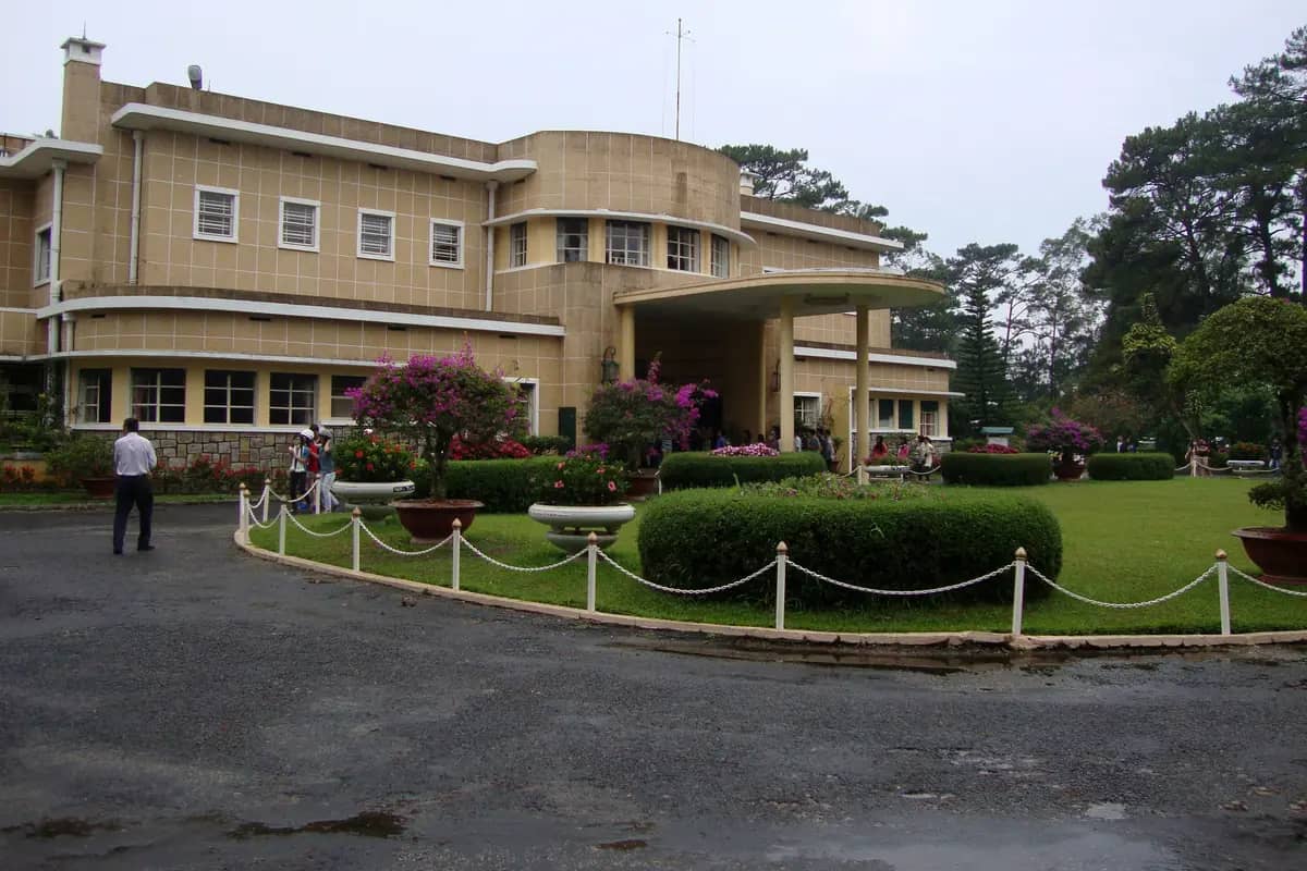 The pale yellow front of Bao Dai's summer palace behind its lawn and flower beds