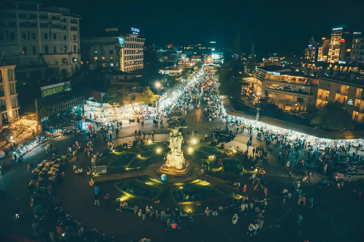 The square by Da Lat market at night, crowds and lit stalls of the night market