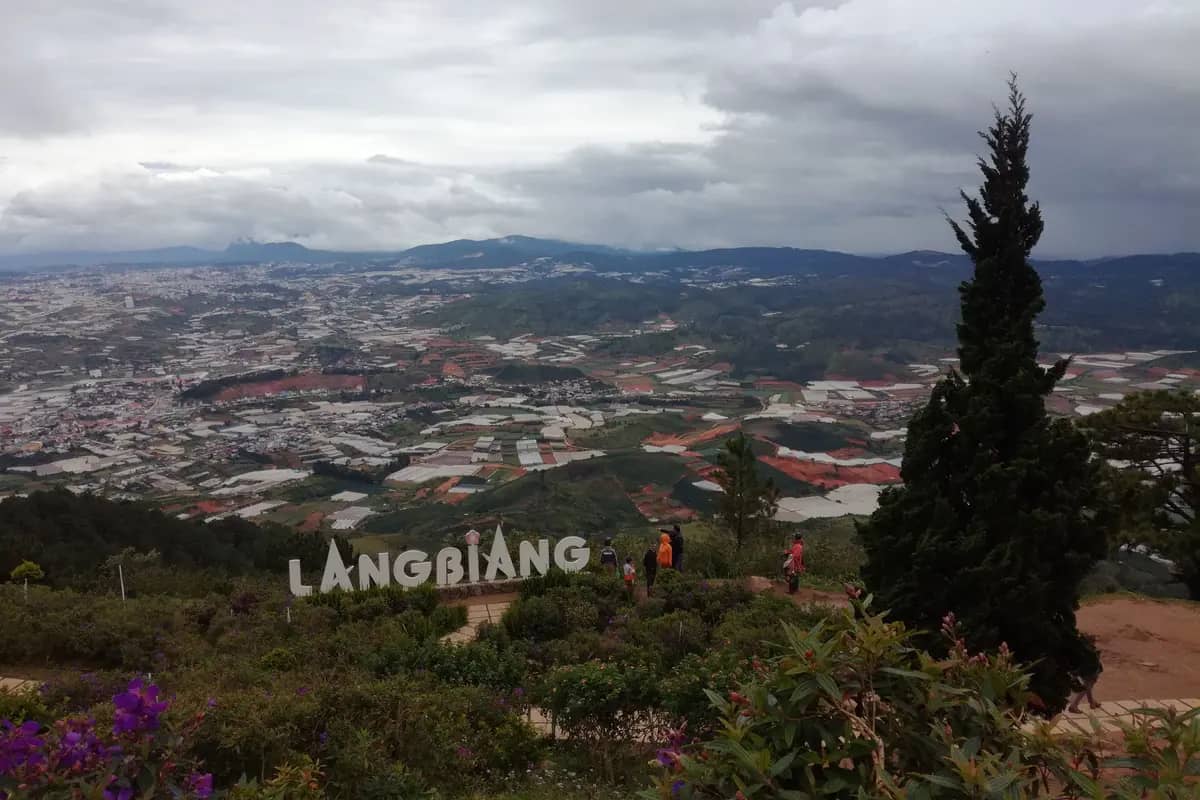 The Langbiang sign at the top of the mountain, the city and its greenhouses spread out below