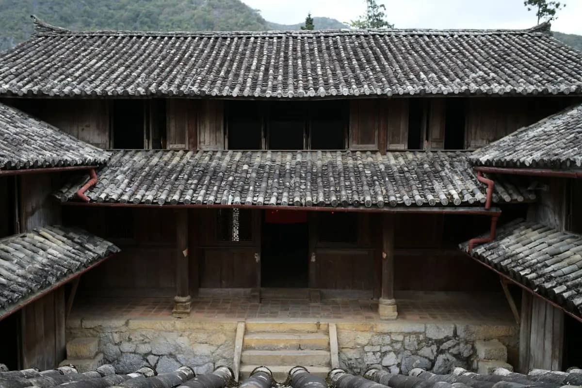 The wooden halls and grey tiled roofs around a courtyard of the Vuong family palace at Sa Phin