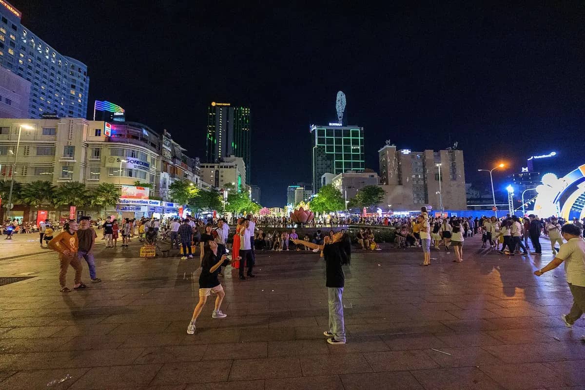 Nguyen Hue walking street at night, people strolling below the lit-up towers