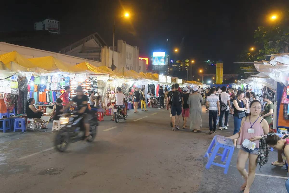 Stalls of clothes and souvenirs lit up along the street at Ben Thanh night market