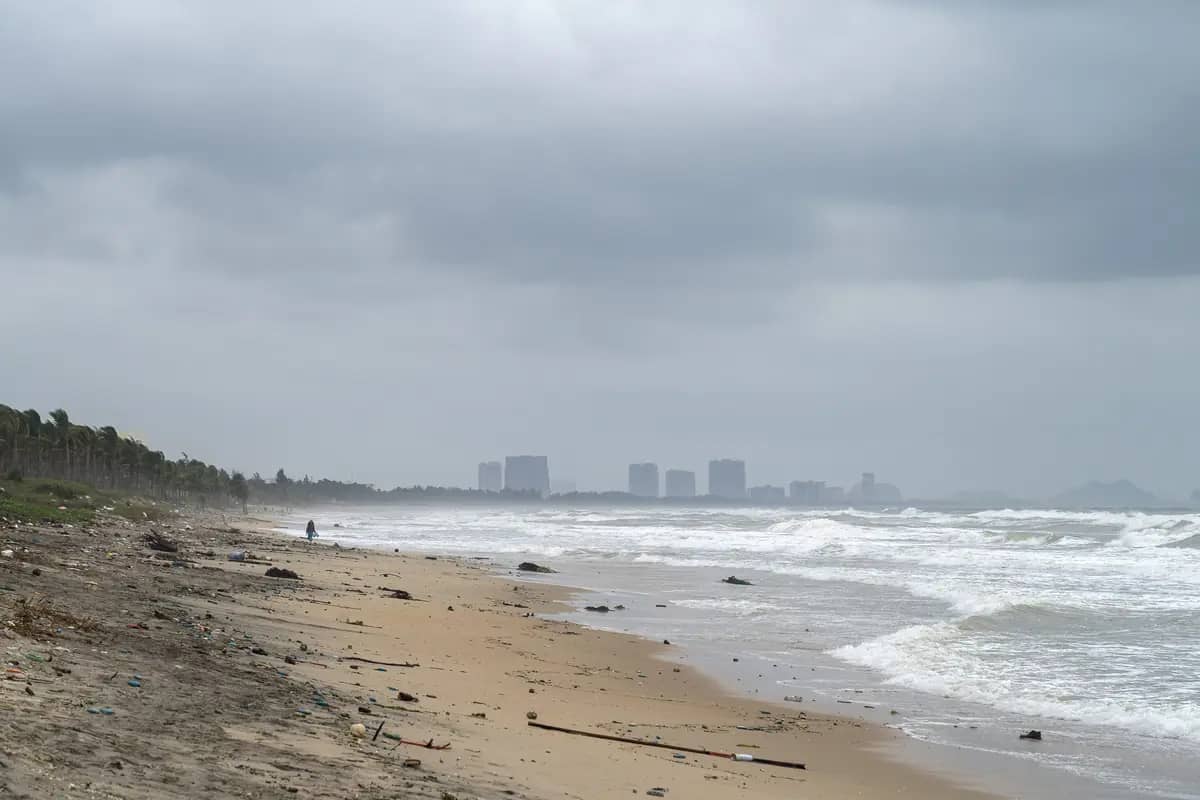 Wide sand and breaking waves at An Bang Beach on a grey November day, tower blocks far up the coast
