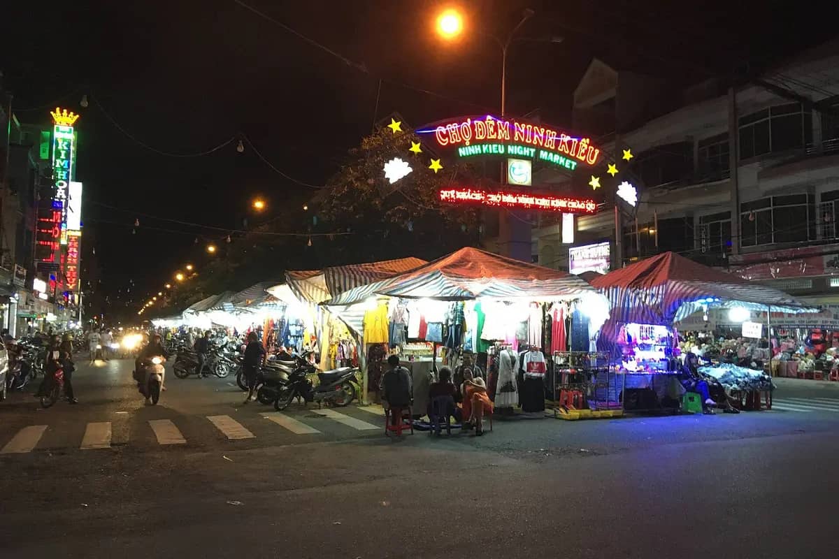 The lit entrance sign of the Ninh Kieu night market and its stalls
