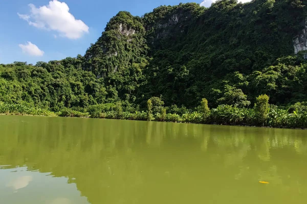 The lake at Thung Nham bird park below a forested limestone ridge