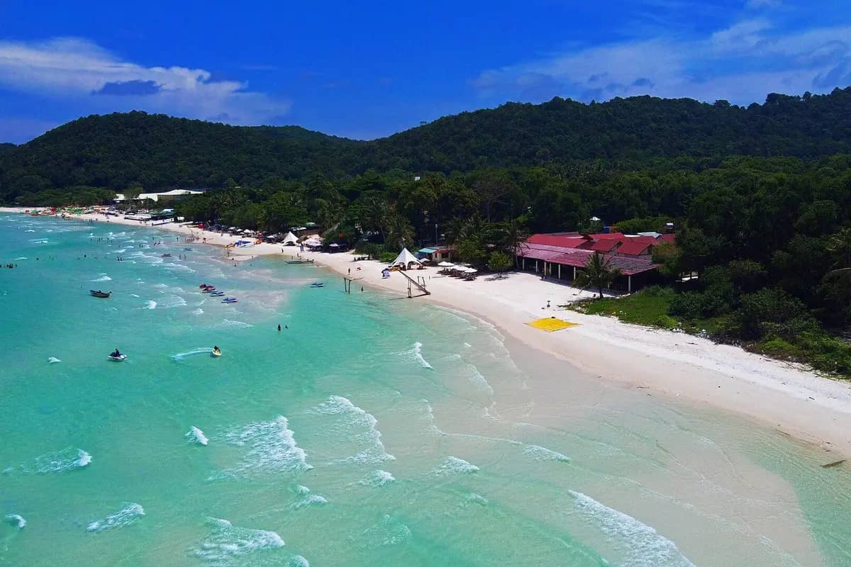 Sao Beach from above: white sand, turquoise water and forested hills