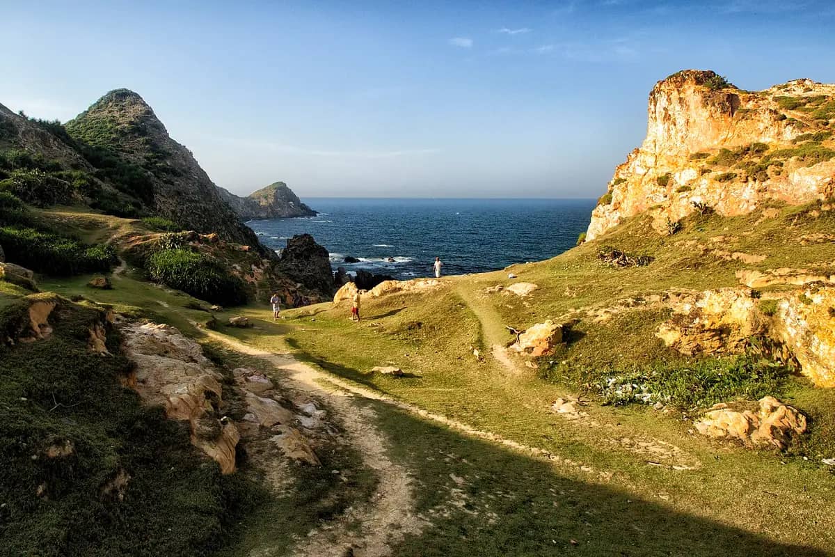 Grassy cliffs and a worn footpath above the sea at Eo Gio