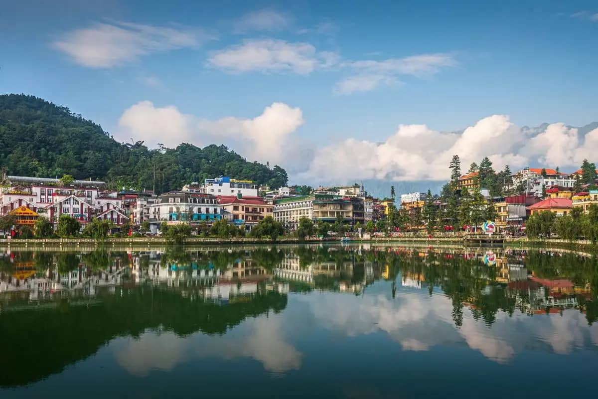 Sa Pa lake on a clear day, the hotels of the town reflected in the still water