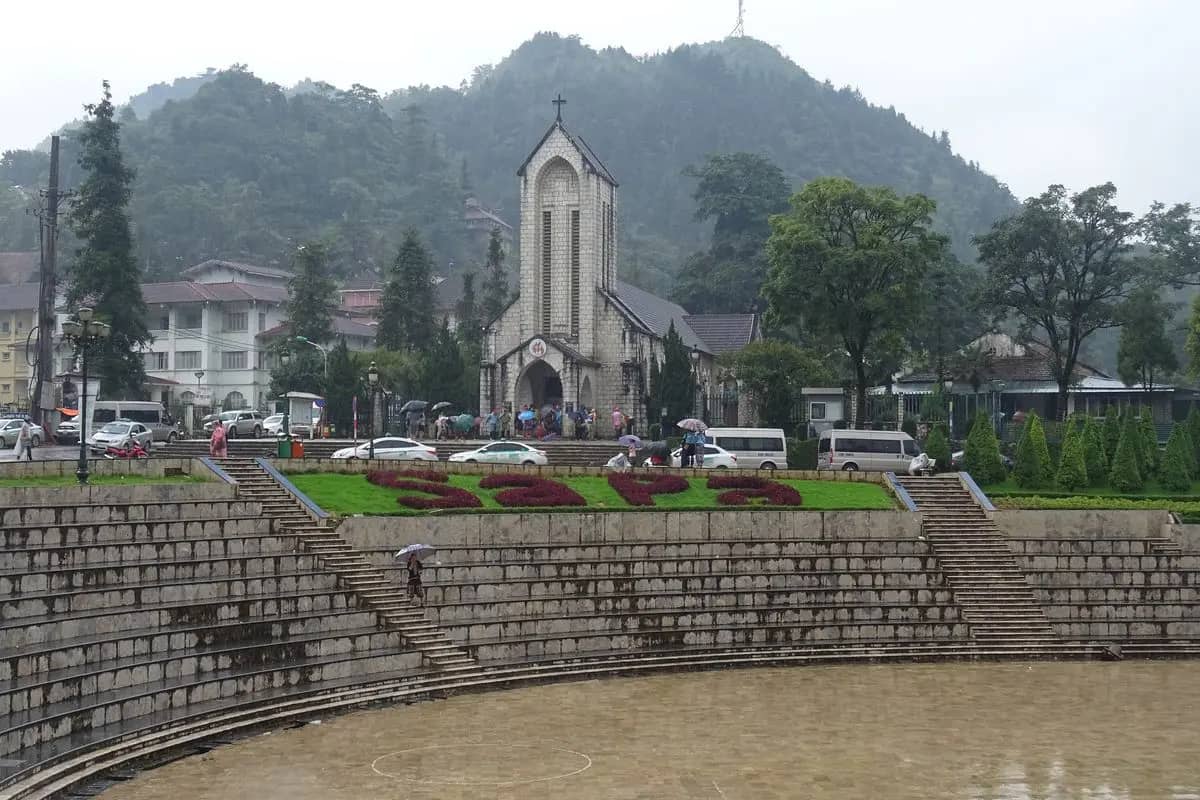 Sa Pa's church square: stone steps and a terraced plaza below the stone church, mountains behind