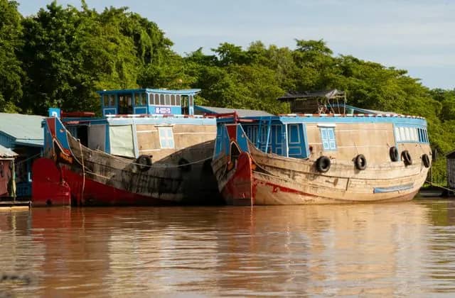 Two old wooden boats moored on the river at Chau Doc