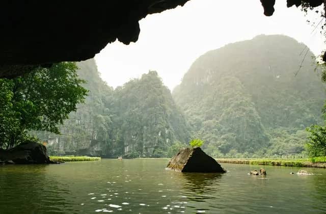 Limestone mountains rising above a calm river in Ninh Binh