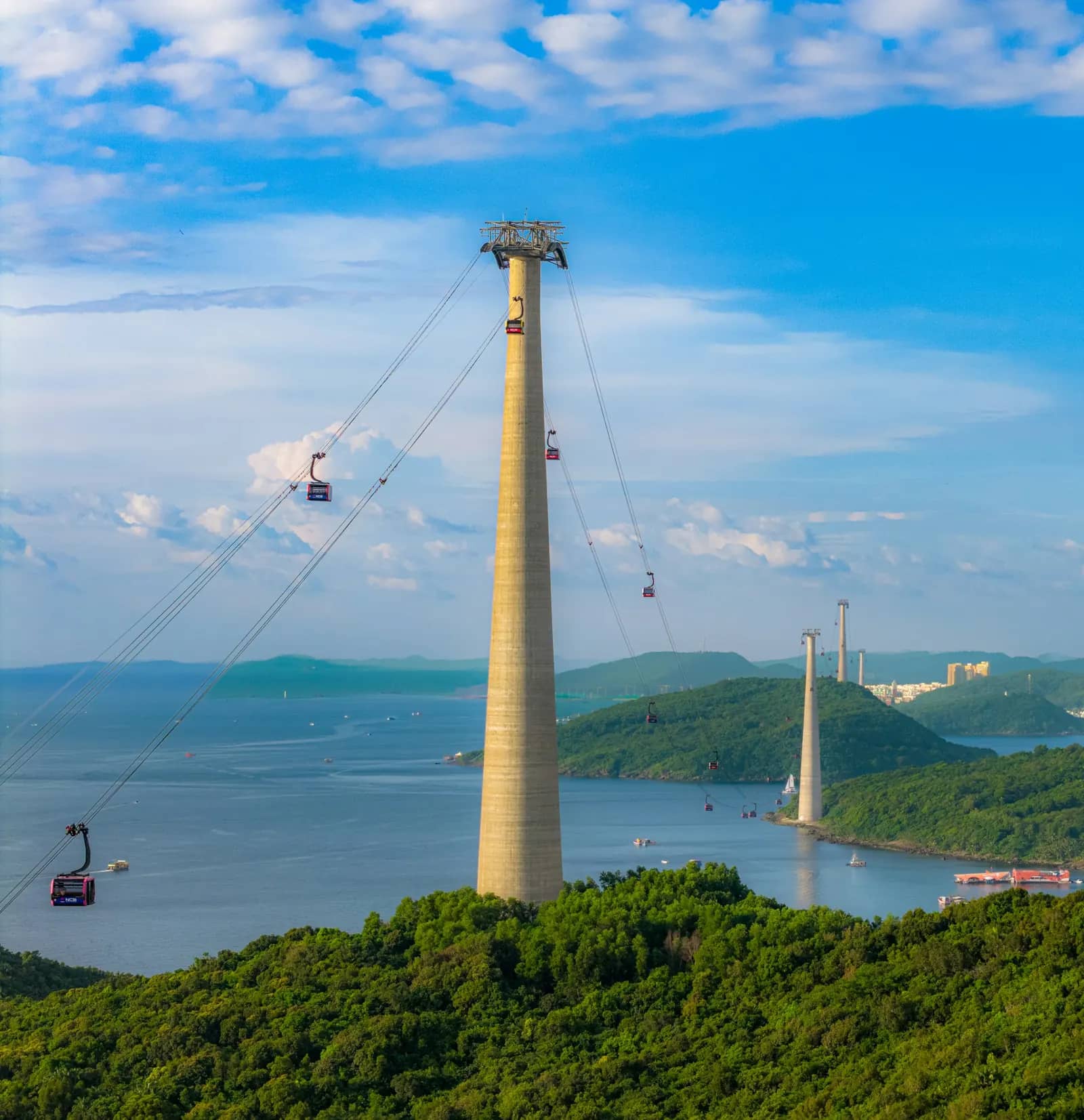 Cable cars travelling between towers over the bay toward Hon Thom