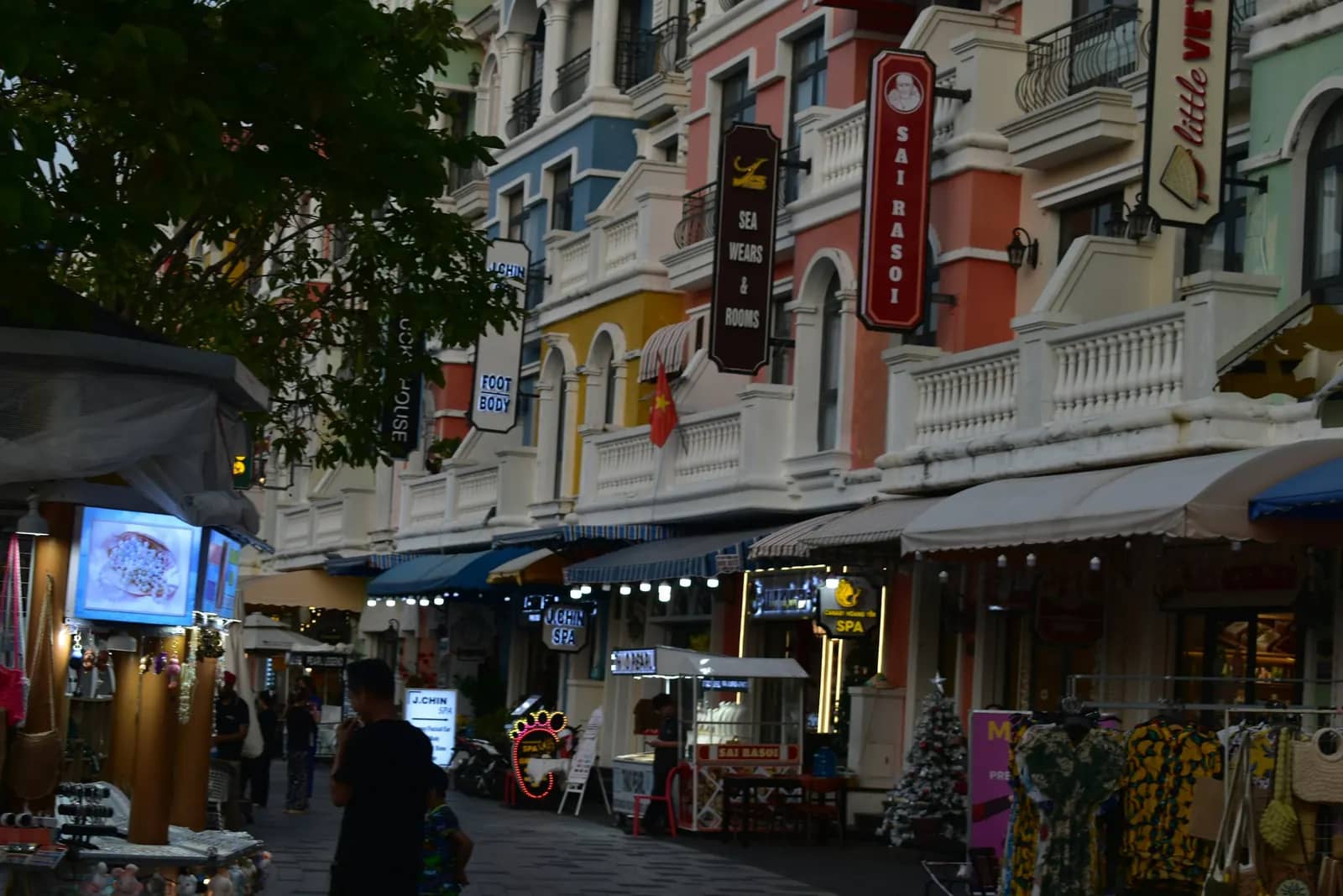 A street of colourful buildings with shops and awnings at Grand World