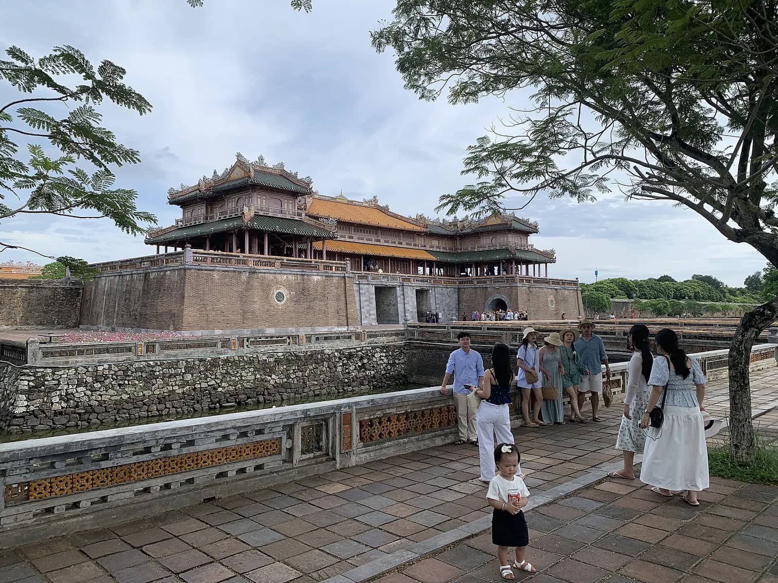 Ngo Mon, the main gate of Hue's Imperial City, with its tiered roof pavilion above a stone base and visitors on the bridge