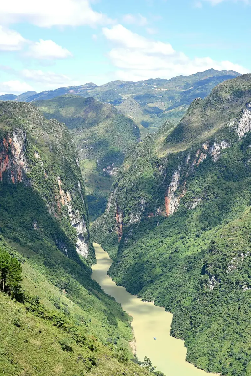 The Nho Que river winding through a deep green canyon below steep limestone ridges in Ha Giang