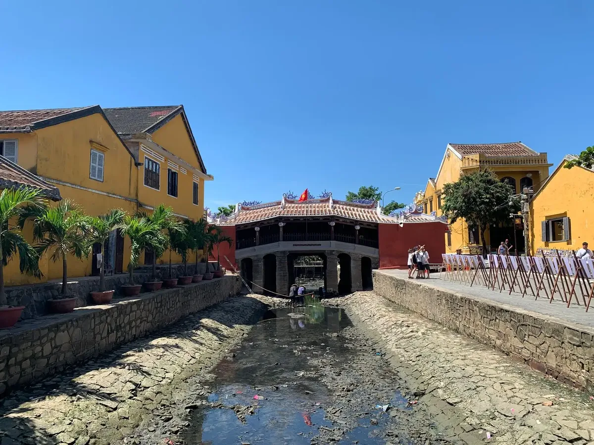 The Japanese Covered Bridge in Hoi An by day after its 2024 renovation, between yellow houses and a stone canal