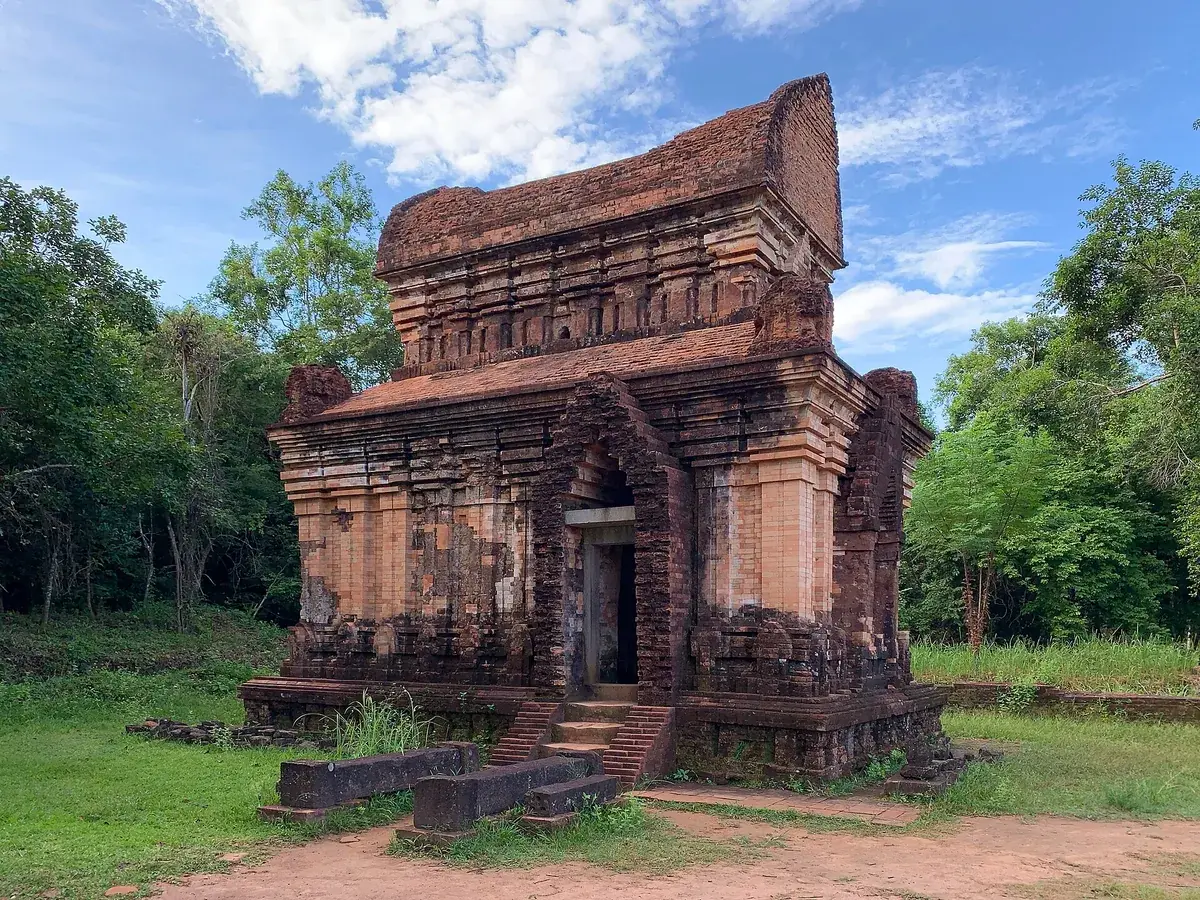 The restored brick kalan E7 at My Son Sanctuary, with steps up to its doorway and trees on both sides