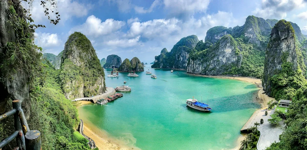 Ha Long Bay from the Surprising Cave lookout, tour boats on turquoise water between steep limestone islands