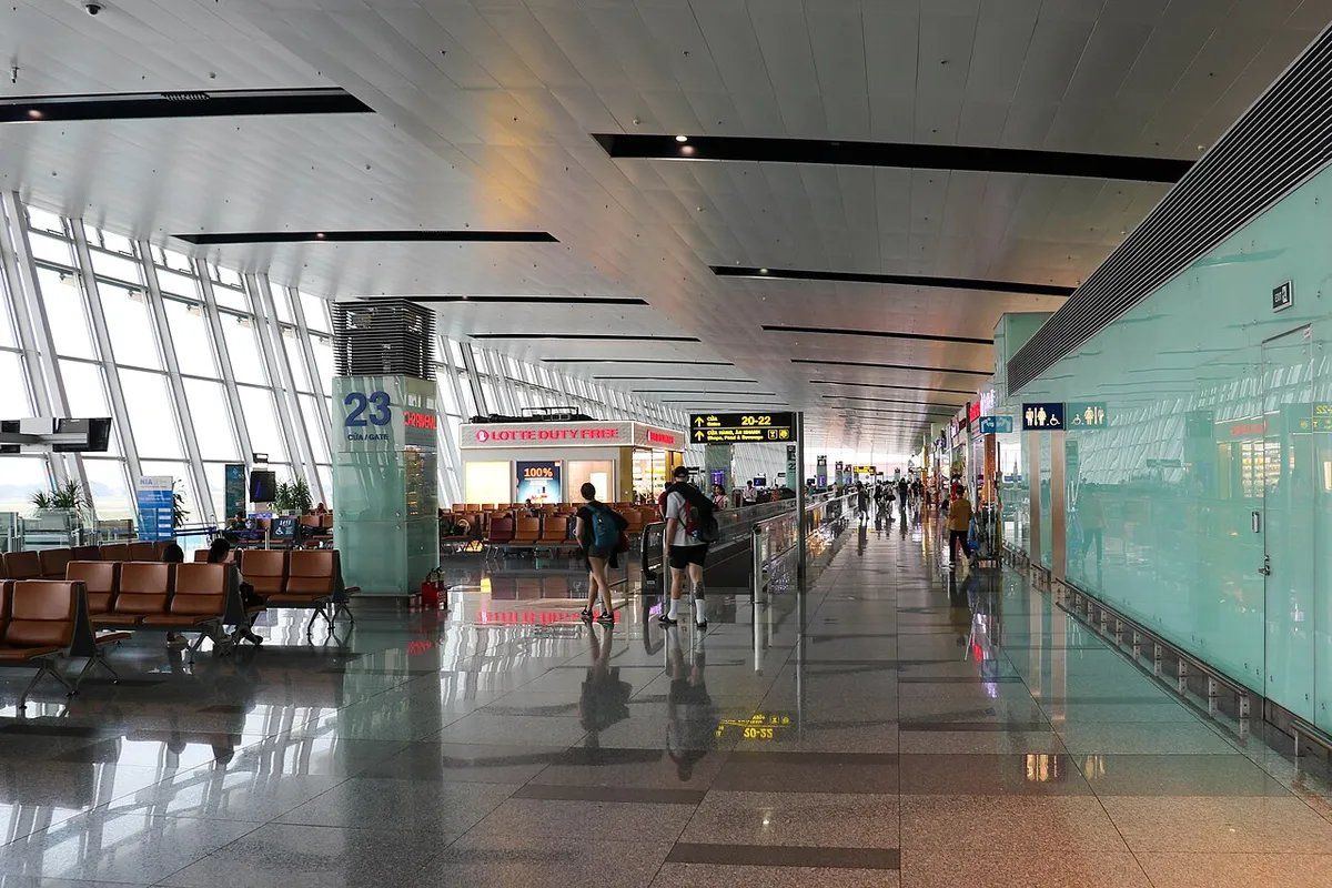 The international departures concourse at Noi Bai airport in Hanoi, with gate 23, seating rows and a glass wall onto the apron