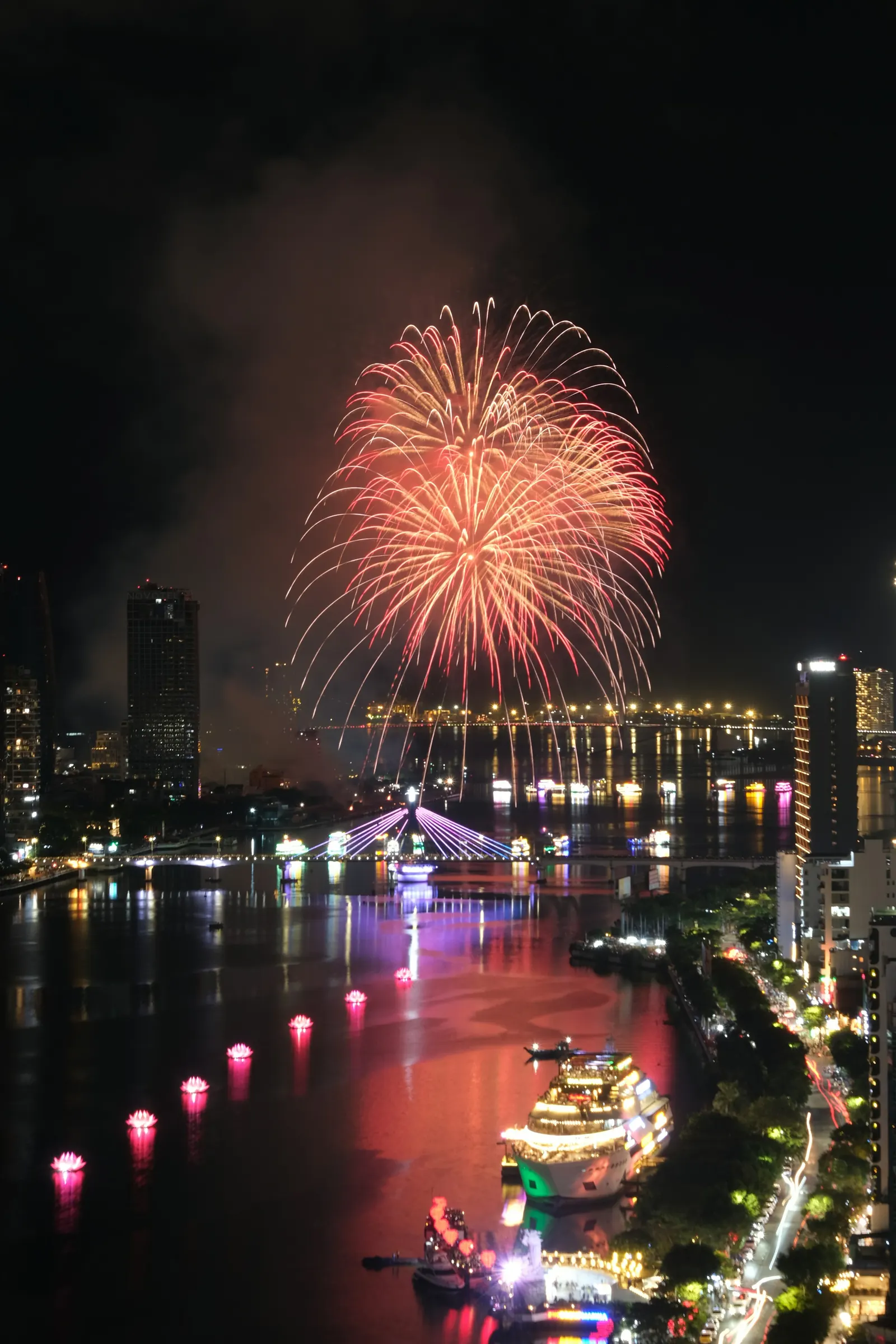 Fireworks over the river and the city skyline at night