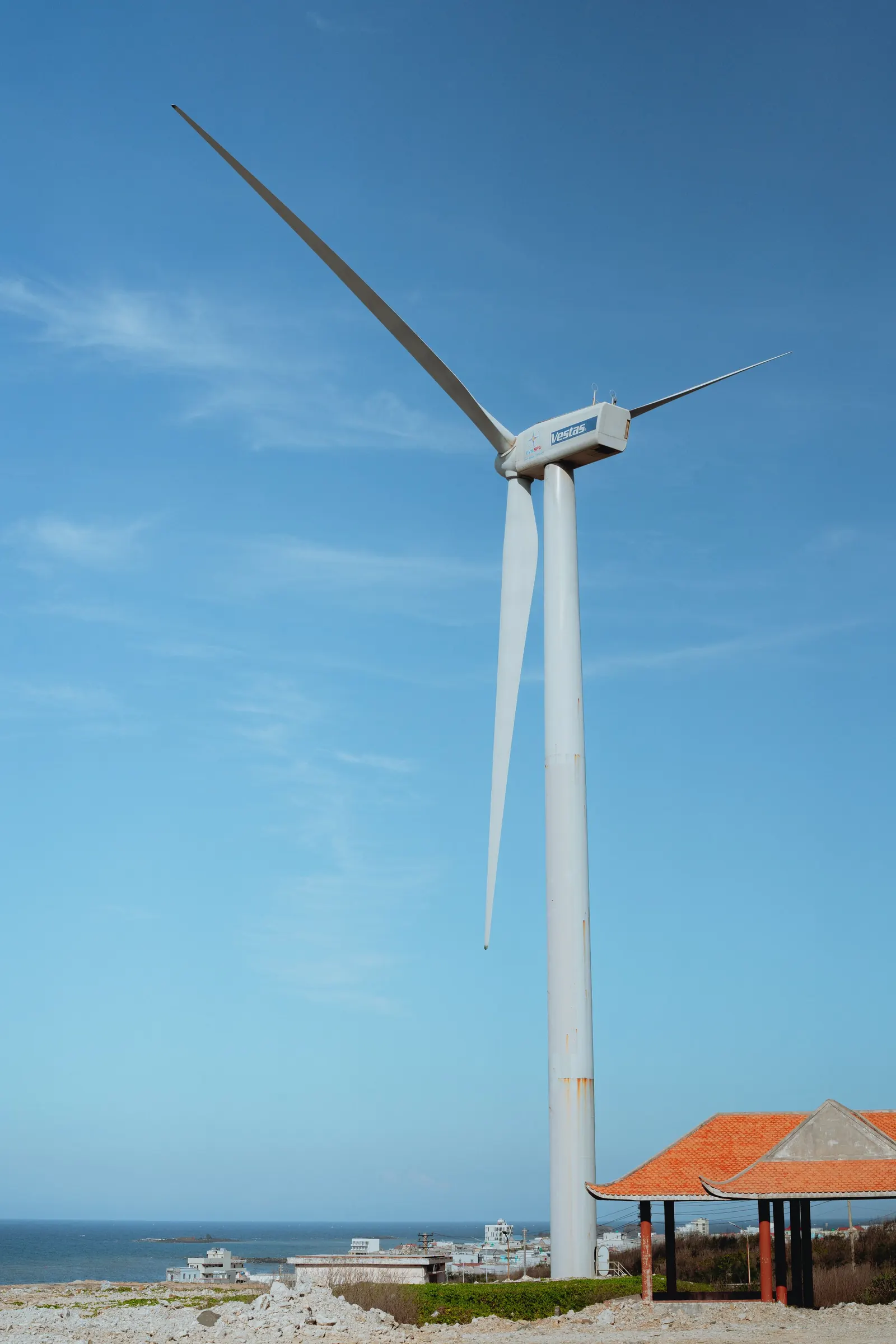 A wind turbine of Phu Quy's wind farm beside a roadside shelter near the sea