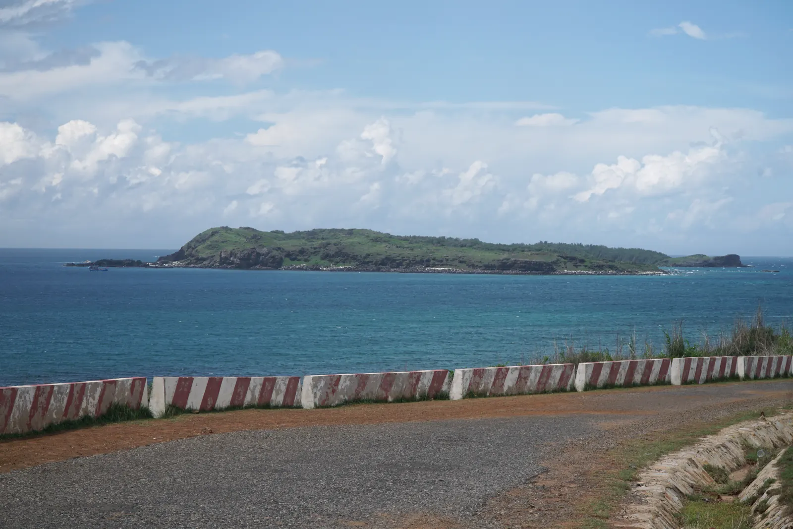 A low green islet off Phu Quy, seen across the sea from the coast road
