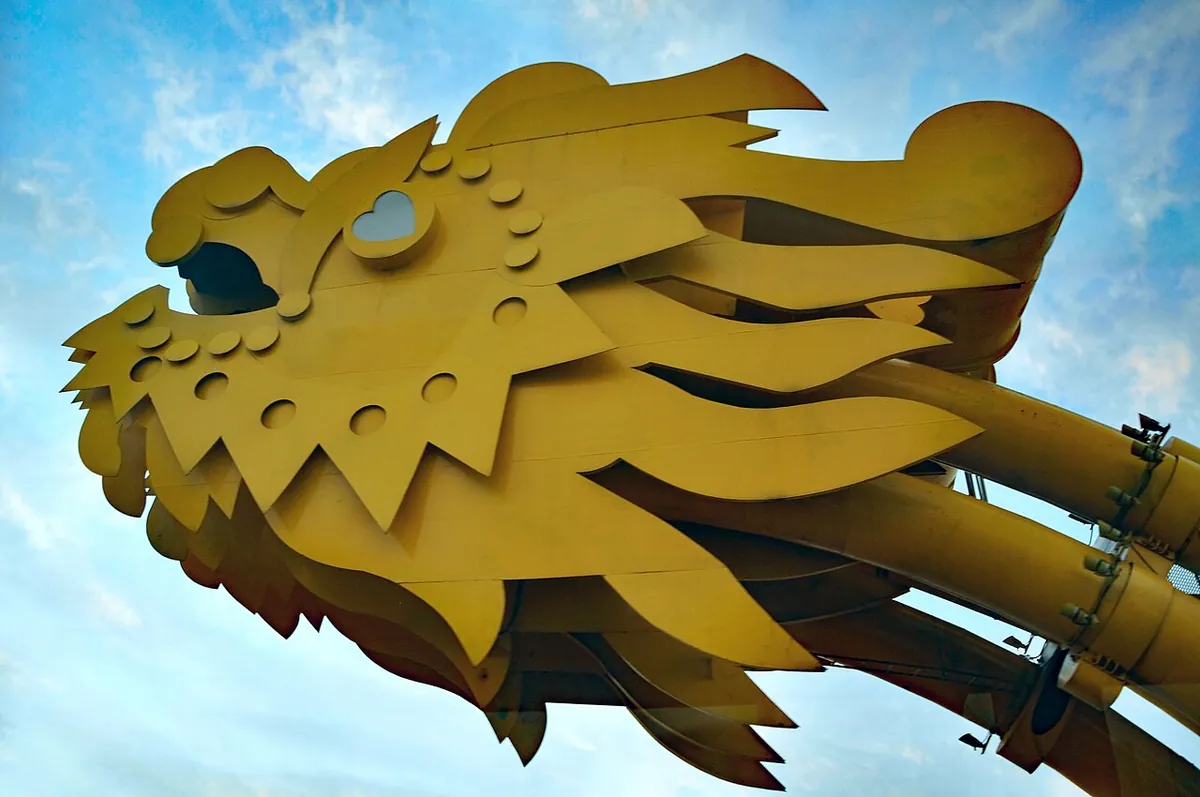 Close view of the golden steel dragon head on the bridge against a blue sky