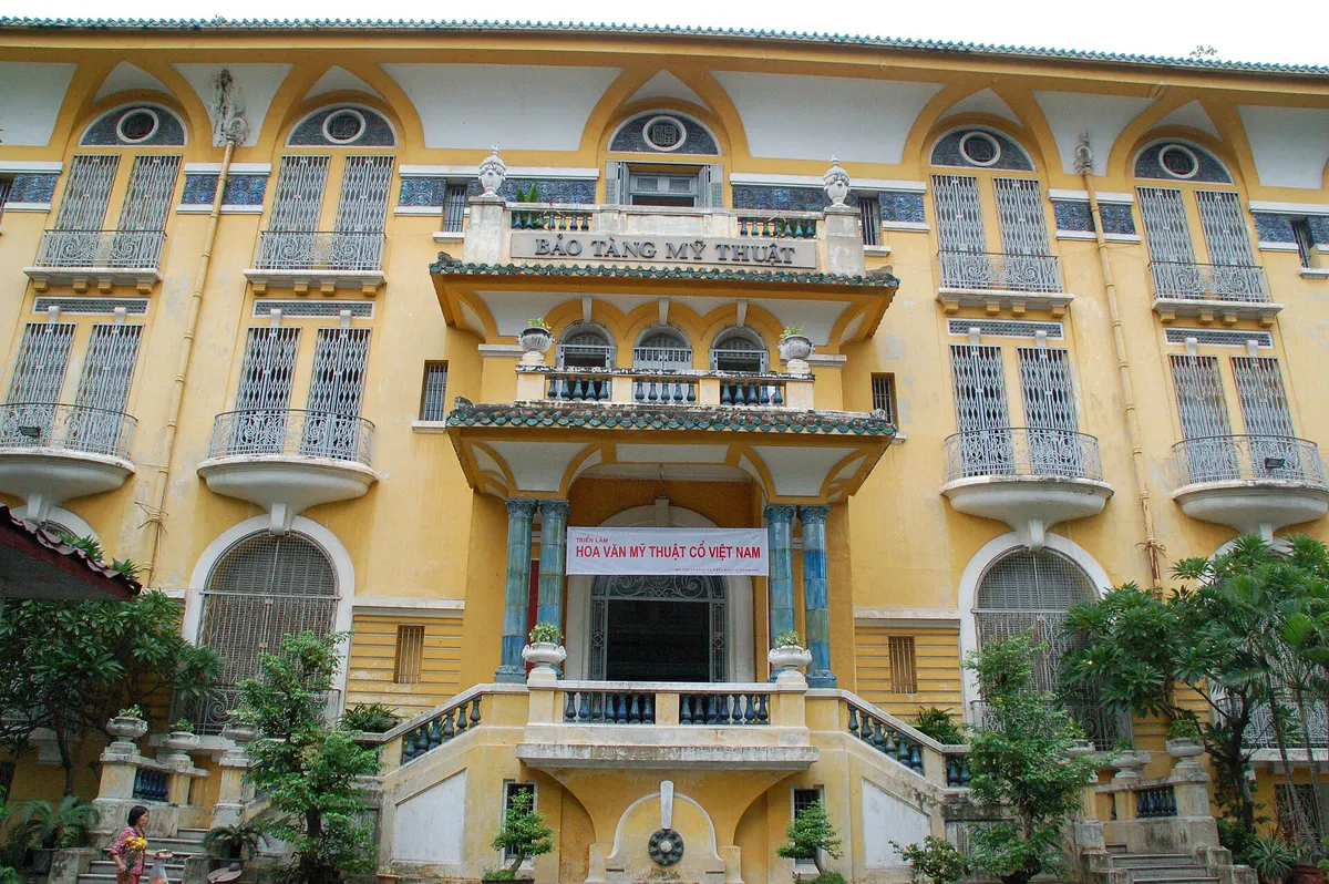 Front of a yellow villa with arched shuttered windows and a balcony carrying the sign Bao Tang My Thuat