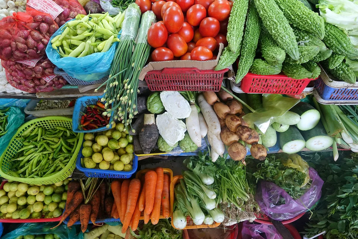 Tomatoes, bitter melon and other vegetables piled on a stall in Han Market