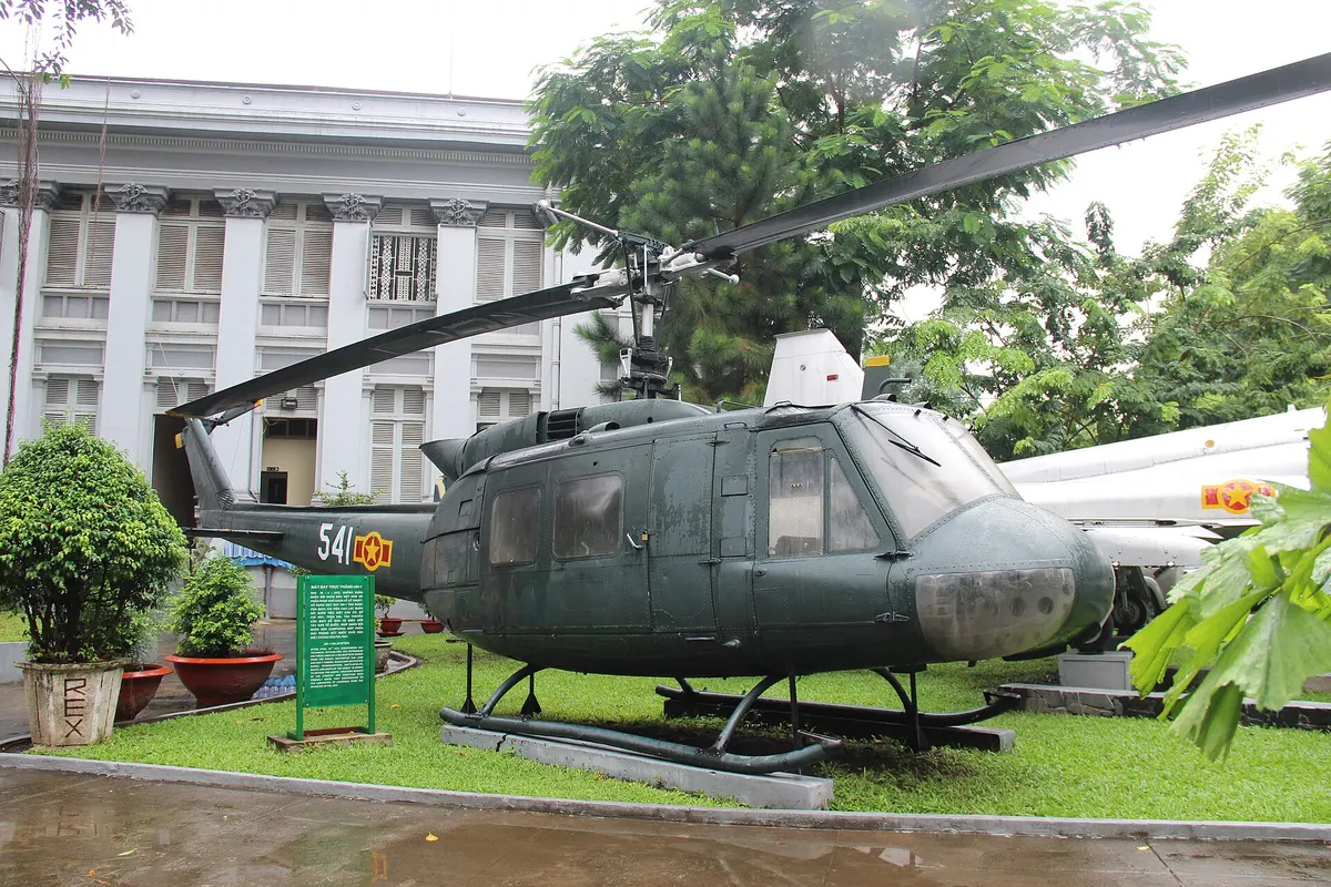 A green Huey helicopter with the number 541 on the lawn in front of the museum building