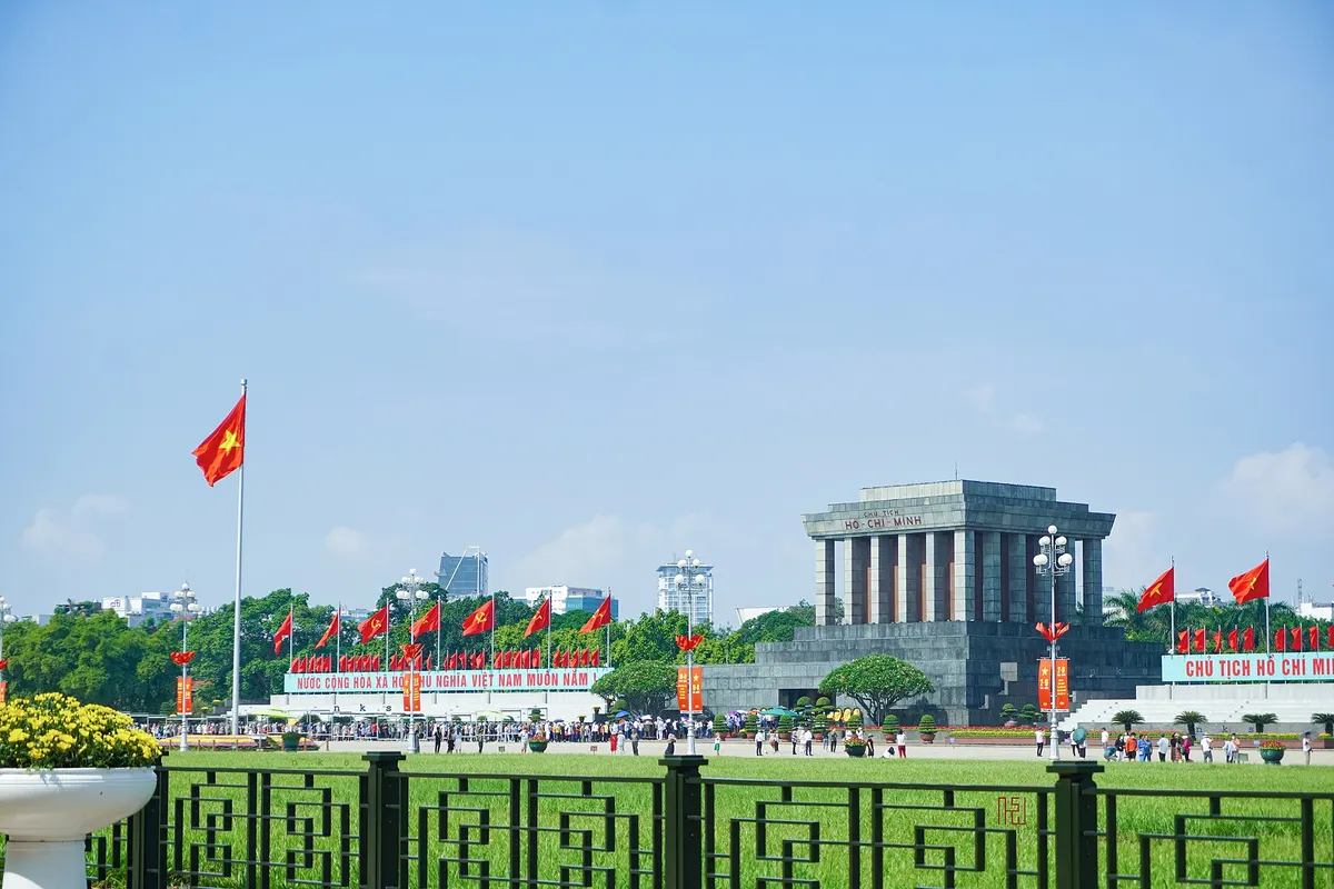 Ba Dinh Square packed with people and red flags on National Day, with the mausoleum in the distance