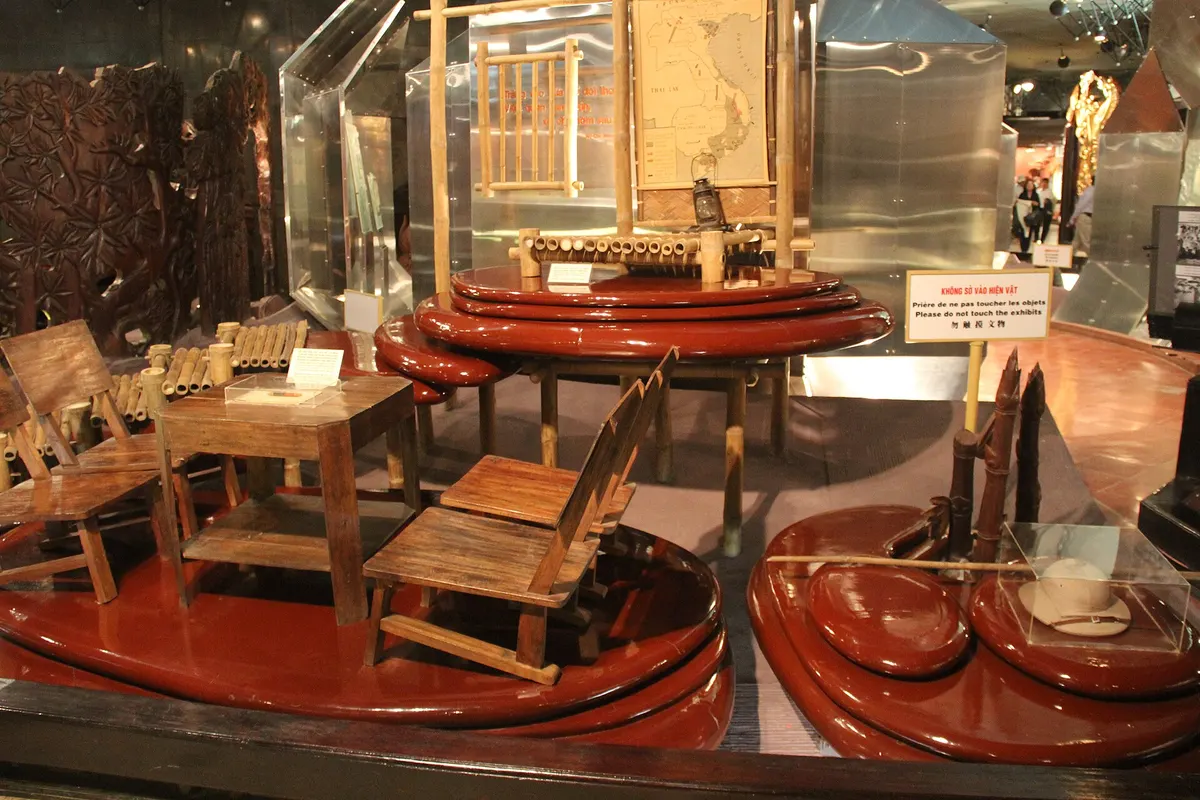 Display cases of wooden furniture set on red lacquered platforms inside the museum