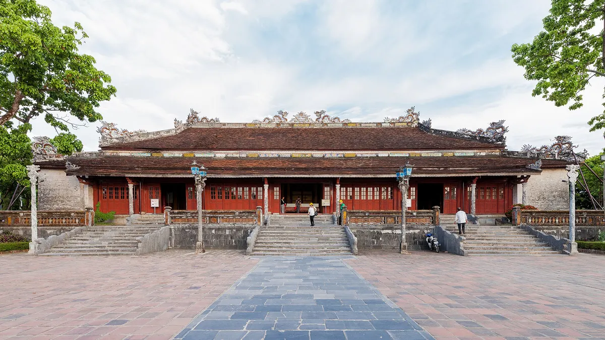 Thai Hoa Palace, a long red-columned hall with a tiled roof, seen across a wide paved courtyard