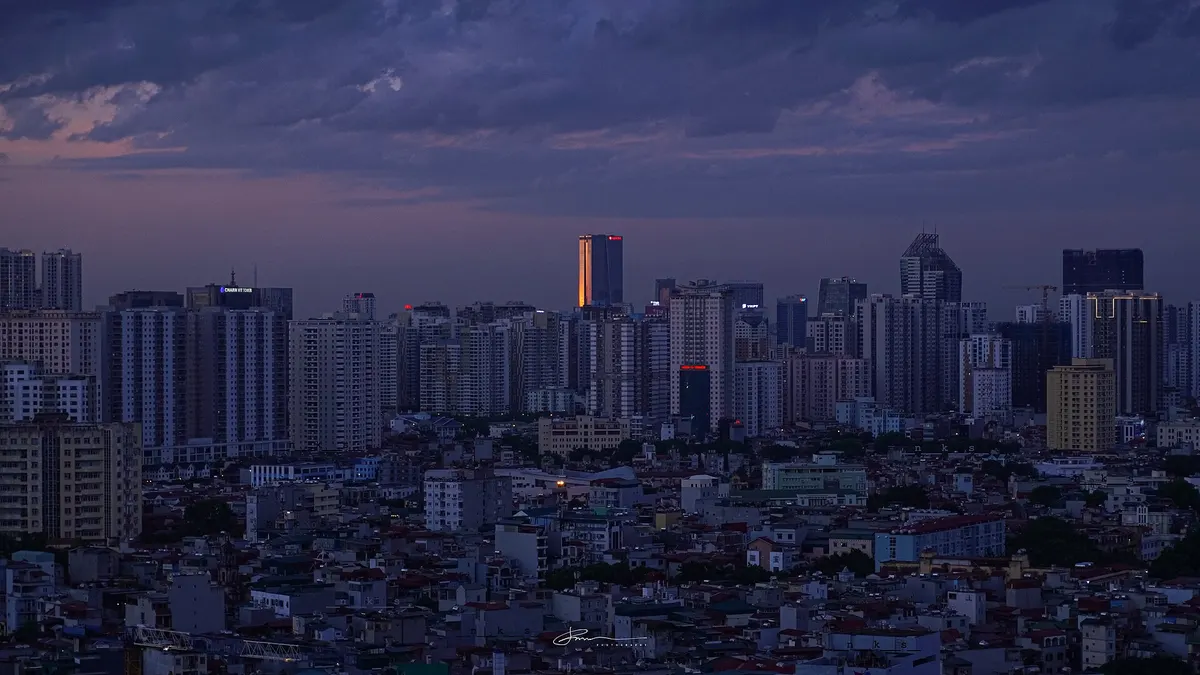 Hanoi's skyline at dusk with the LOTTE tower standing above the other high-rises, its top lit orange