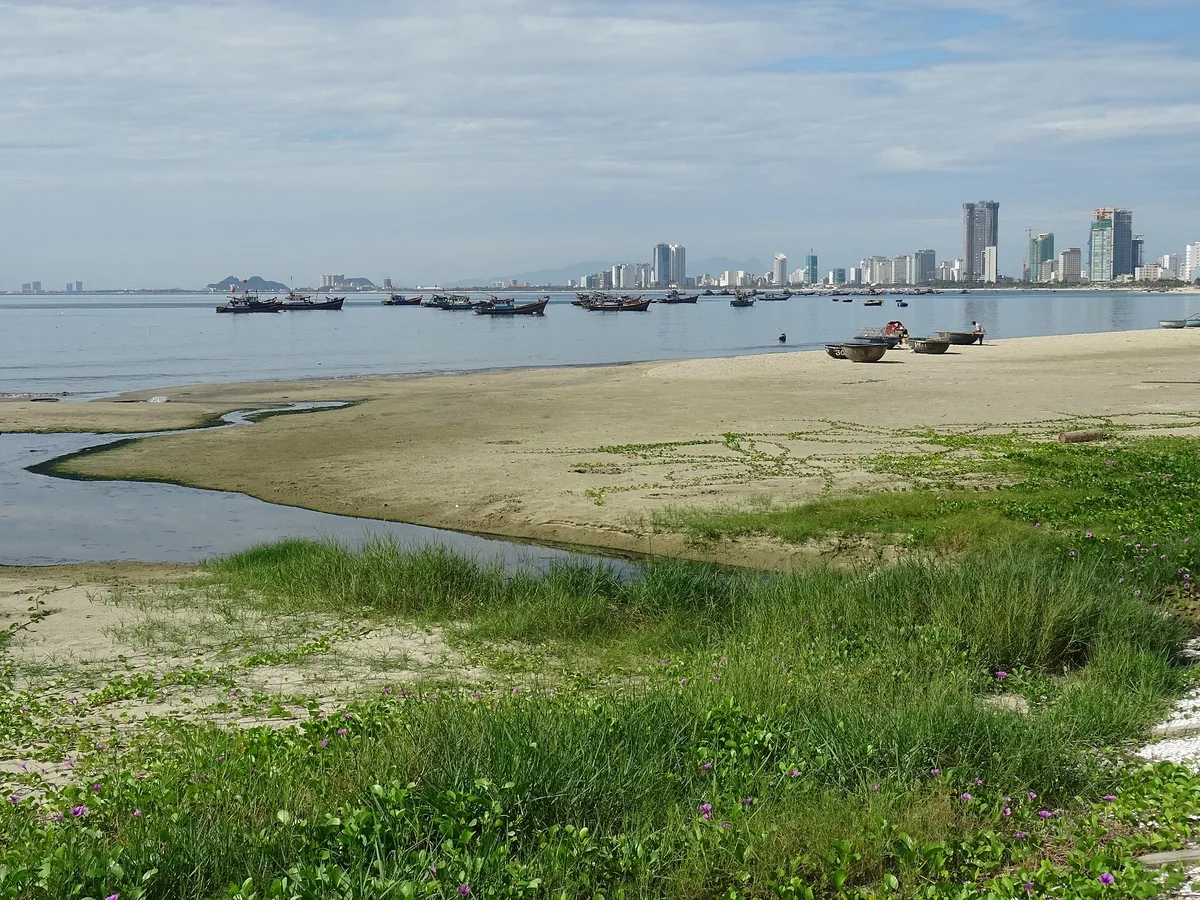 Fishing boats moored off the northern end of My Khe Beach, with Da Nang's buildings across the water