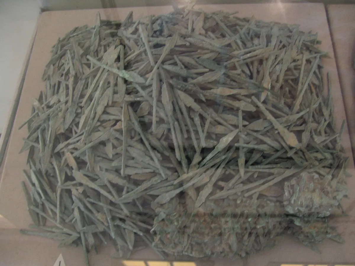 A heap of bronze arrowheads in a display case