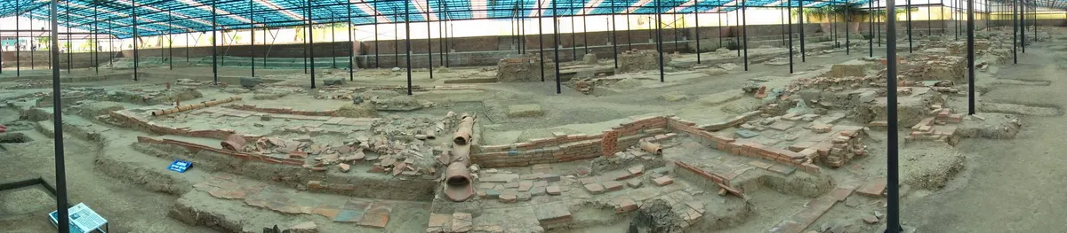 A wide panorama of excavated brick foundations under a roof at the 18 Hoang Dieu archaeological site