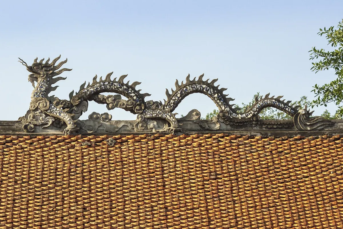 Ceramic dragons curling along the tiled roof ridge of Doan Mon