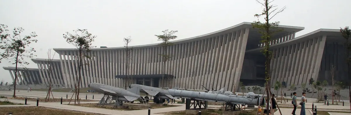The museum's long, low building with a sloping finned roof, with missiles lined up on the forecourt