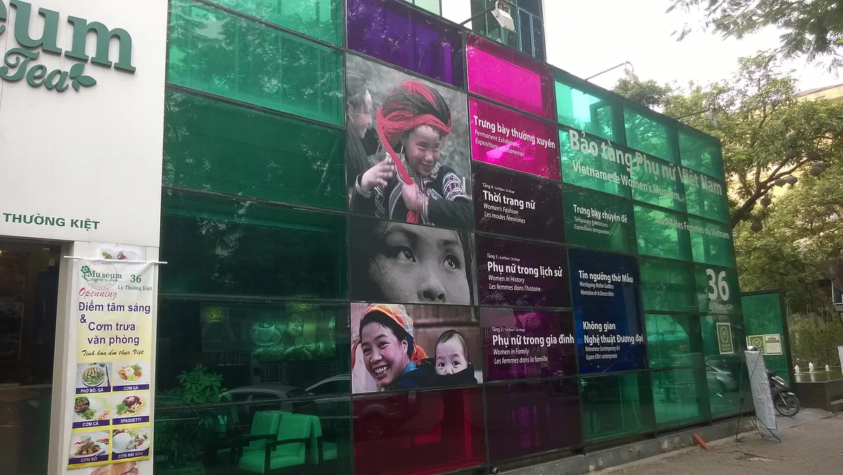 The museum's street front, a wall of green glass panels printed with portraits of women in traditional dress